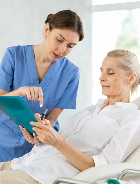 A dental office staff member explaining a treatment plan to a patient