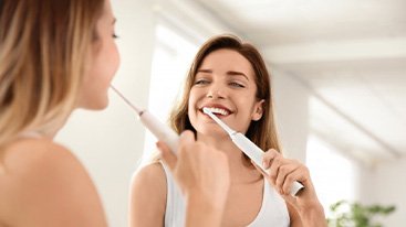 Invisalign patient in Hamden brushing teeth