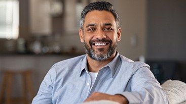 Man smiling while sitting in couch at home