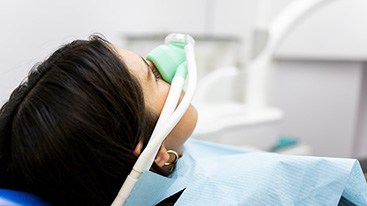 Closeup of patient breathing in nitrous oxide in treatment chair
