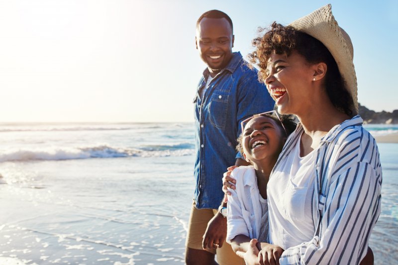 Patient with Invisalign on the beach with family