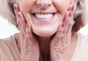 Close up of senior woman smiling and touching her cheeks